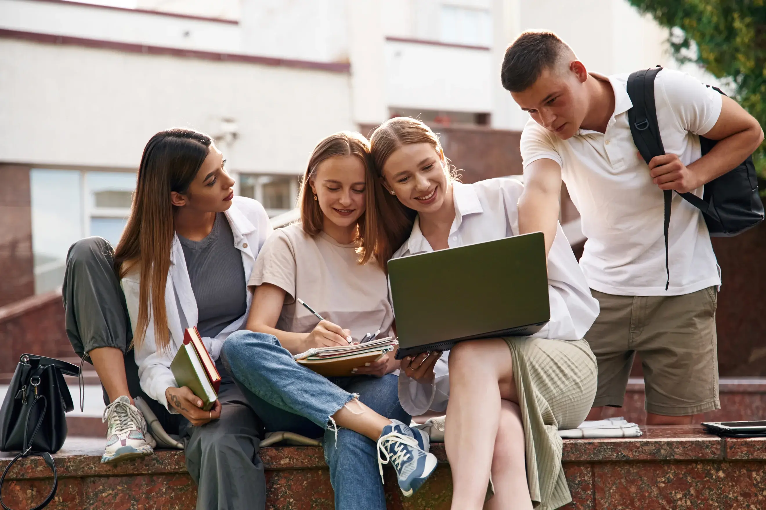 Gruppe von vier Studierenden, die in einen Laptop schauen