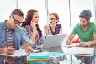 Mehrere Studierende arbeiten als Team an einem Laptop